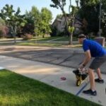 a man pushing a cart on a sidewalk